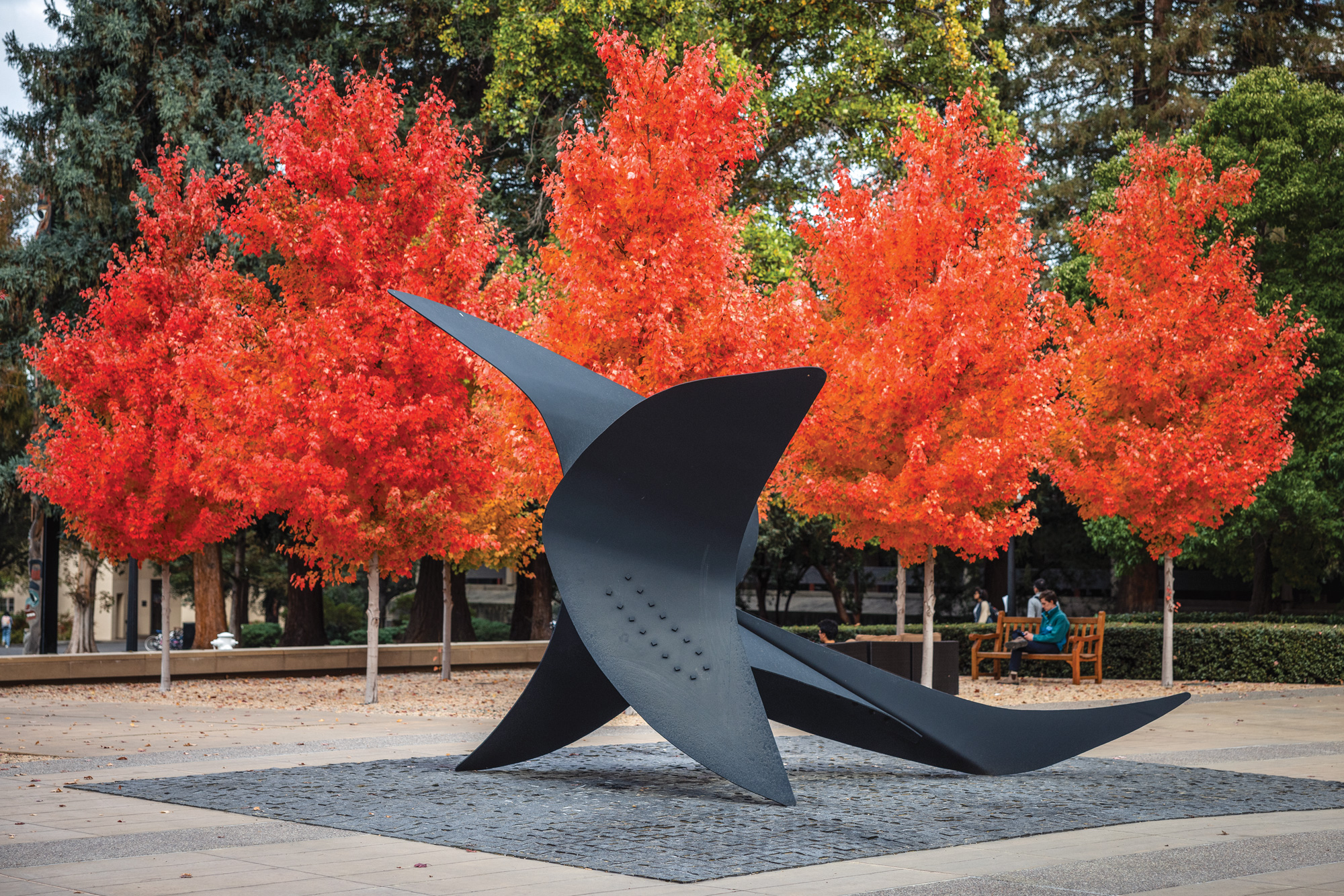 The Falcon statue in front of bright orange-leafed trees