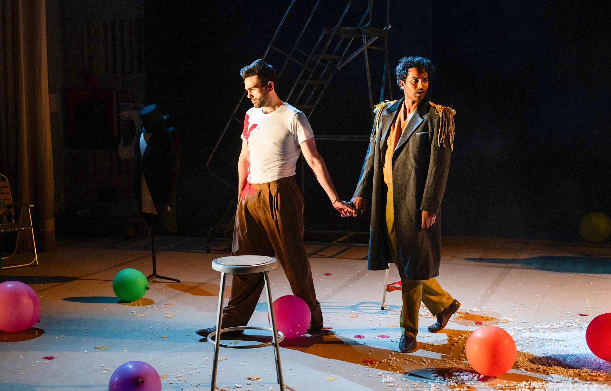 Roy Hage and another actor on stage with a stool and colorful balloons