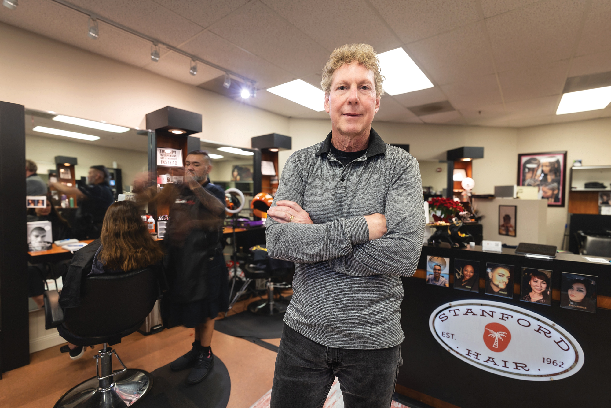 Kleis in the salon, with a stylist and client in the background.