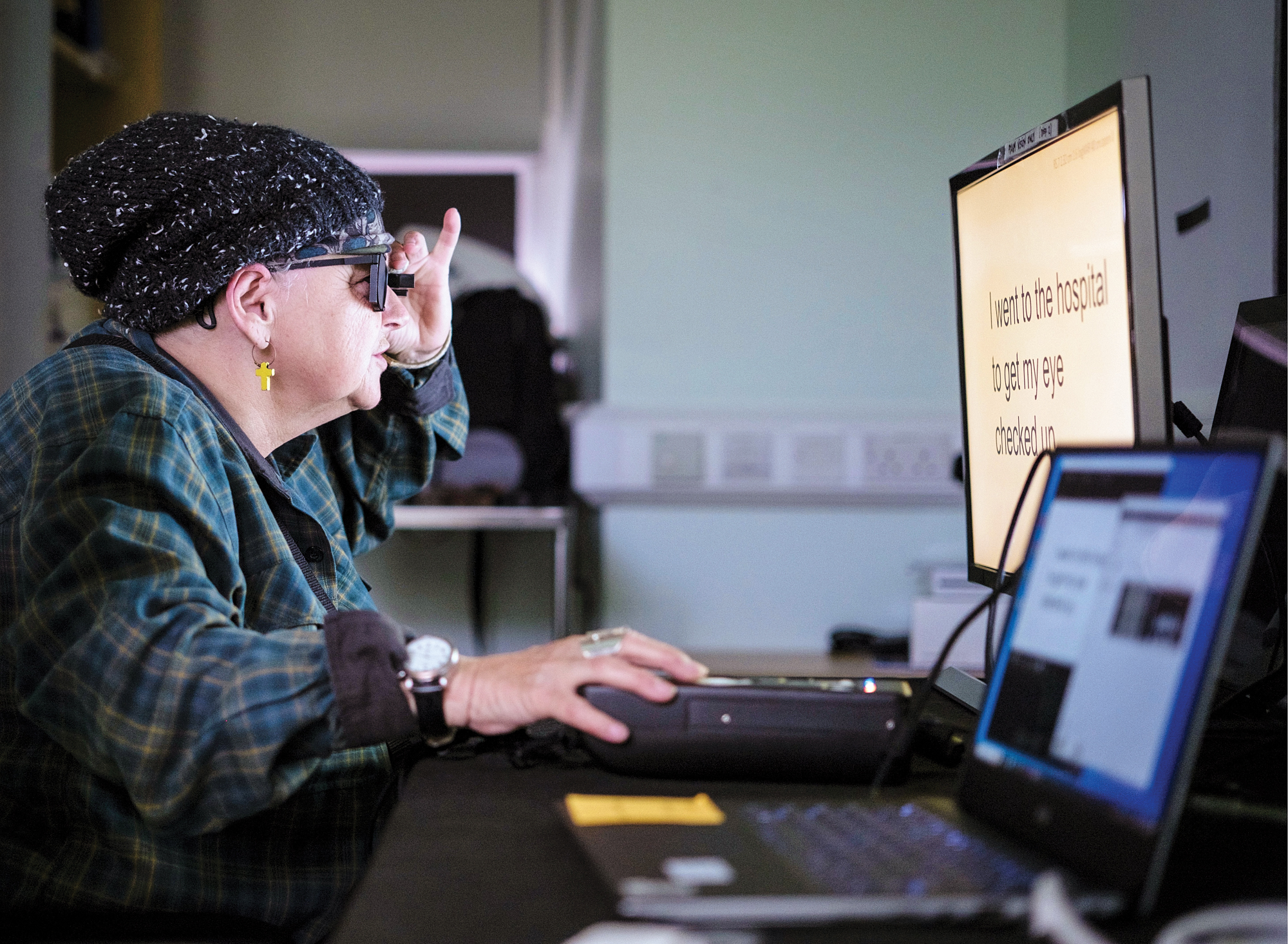 Sheila Irvine in front of a computer screen with large words
