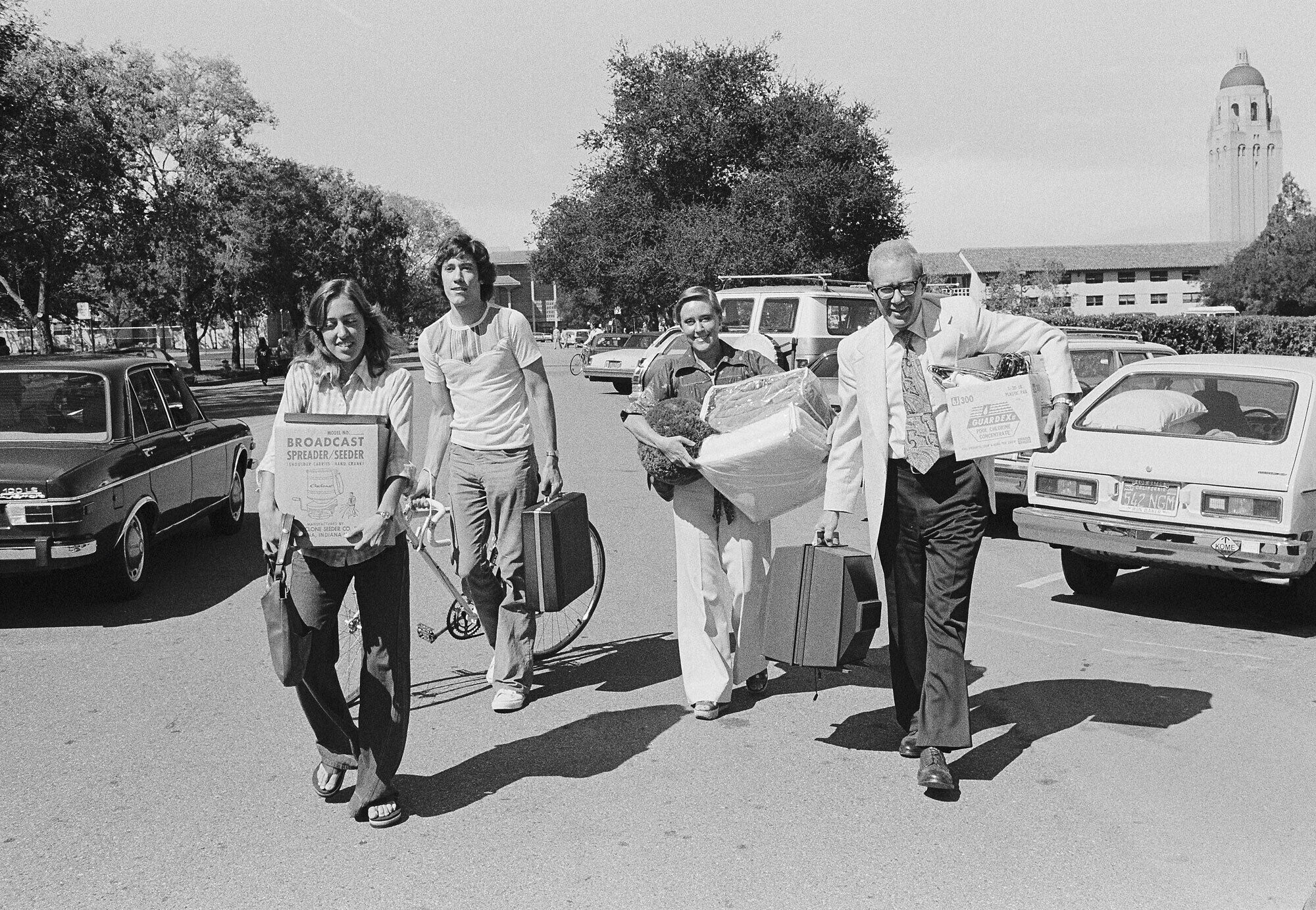 Amy Walker Slankard, her brother, and her parents, walks down Escondido Road. Each person is carrying items for her dorm room.