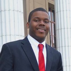 Michael Tubbs wearing a suit with a red tie.