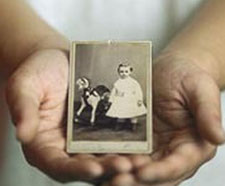 A photo of two hands cupping a black-and-white photo of Leland Stanford as a young boy.