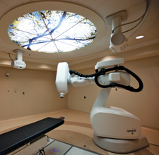 An image of Cyberknife, a large arm-like machine with a small nozzle on the end.