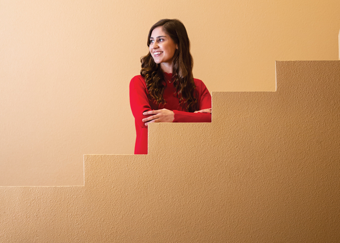 Profile of Ann Marie Abraham, resting her arms on stairs.