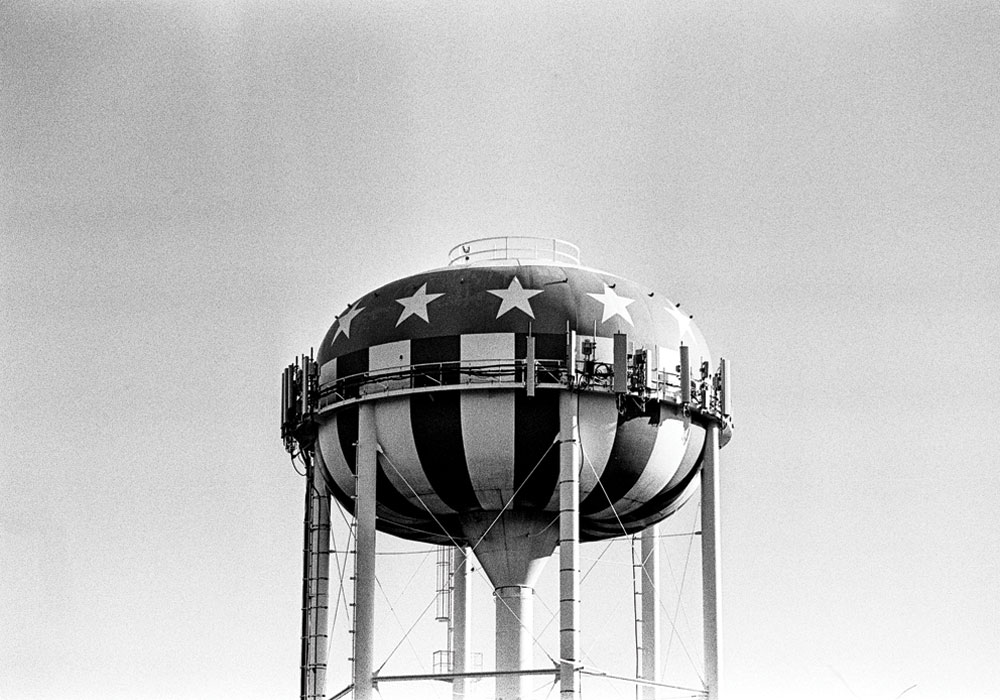 The top of a water tower, painted to look like an American flag.