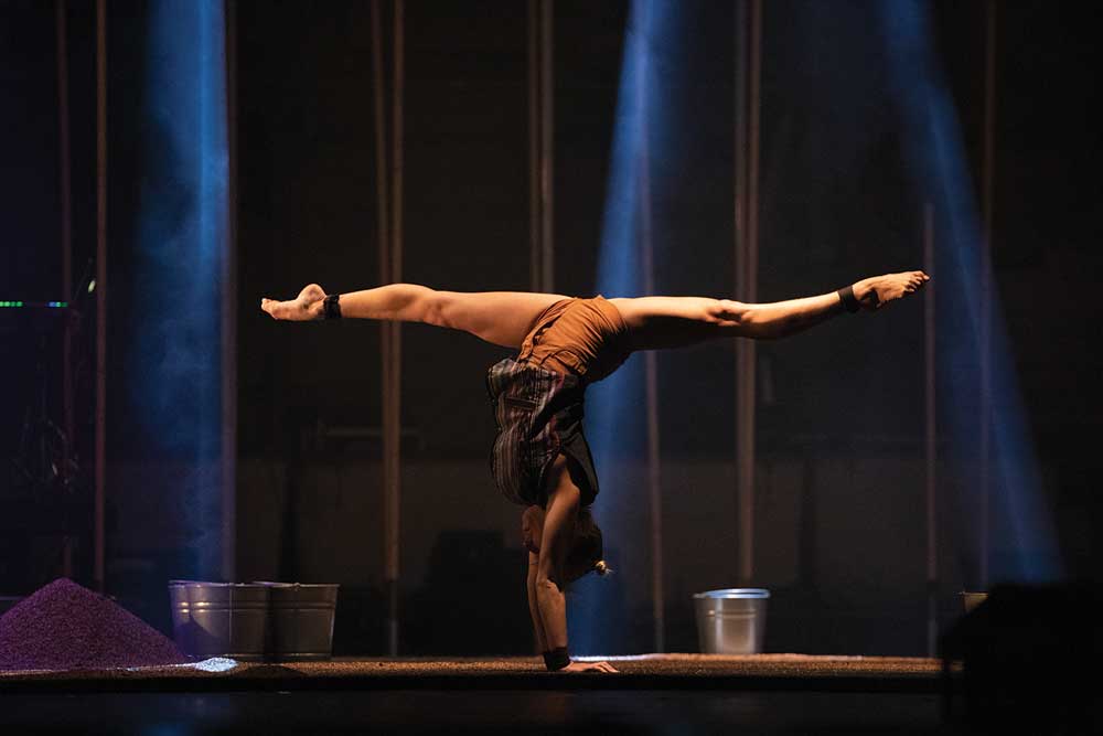 Acrobatic performer doing a handstand split.