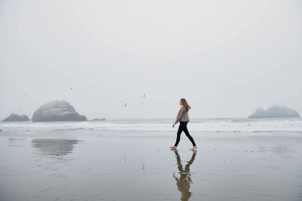 Lopez-Nandam walks along the coast on an overcast day.
