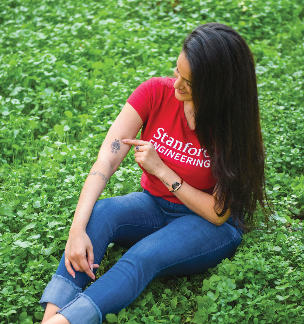 Photo of Luciana Frazao pointing at her robot tattoo.