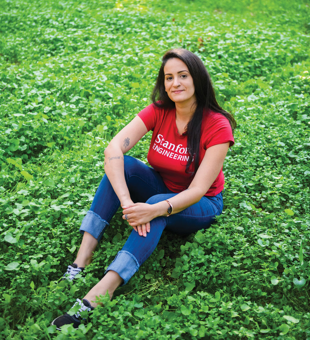 Photo of Luciana Frazao in a bed of green herbs.