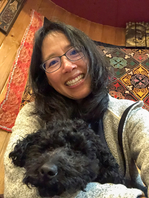 Grace Chin Hartman snuggling a black dog