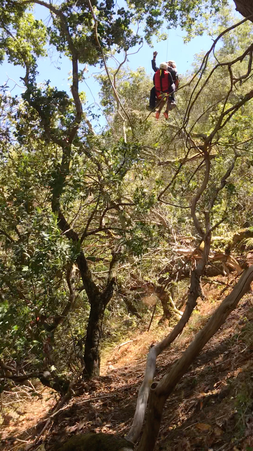 Rescuer and hiker being lifted out of the wilderness