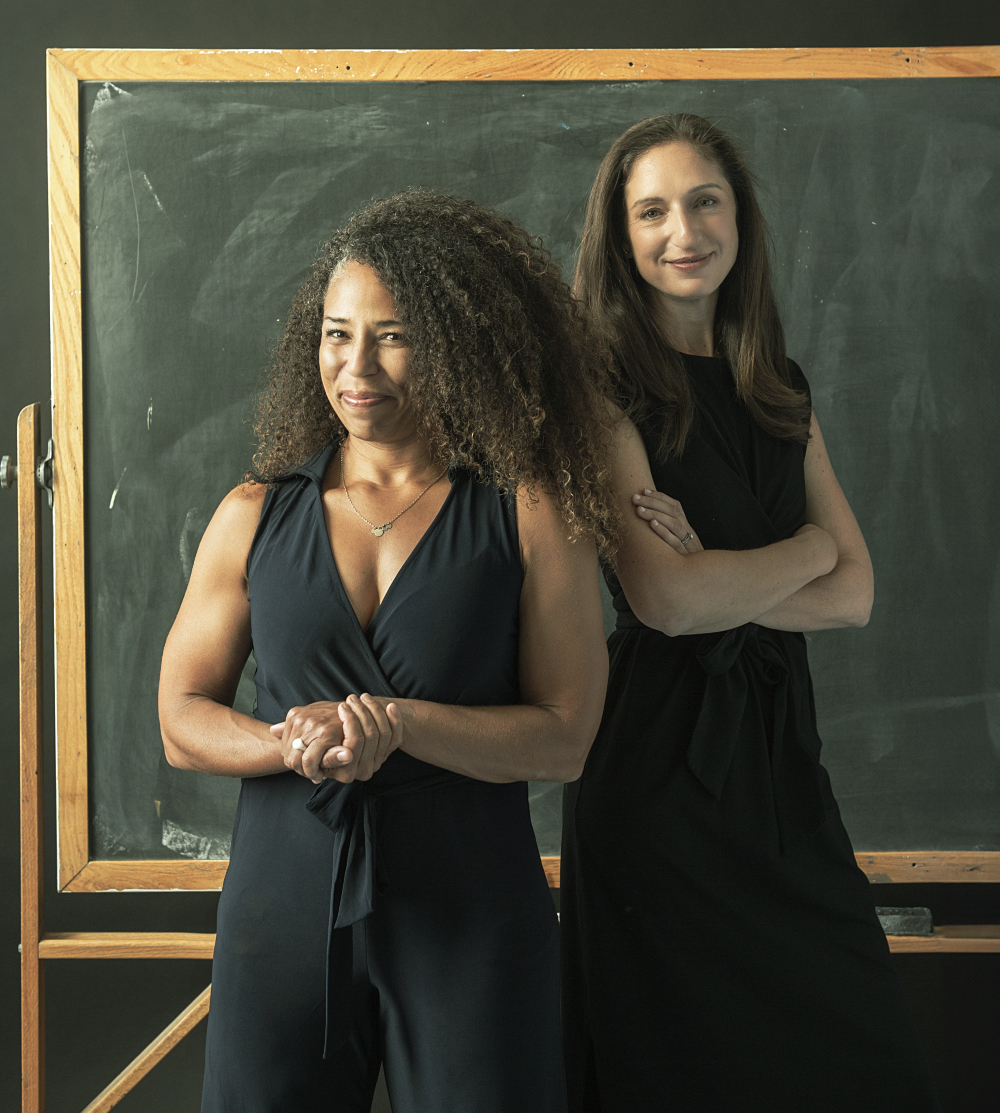 Gina Sudaria and Jenna Wachtel Pronovost standing in front of a chalkboard