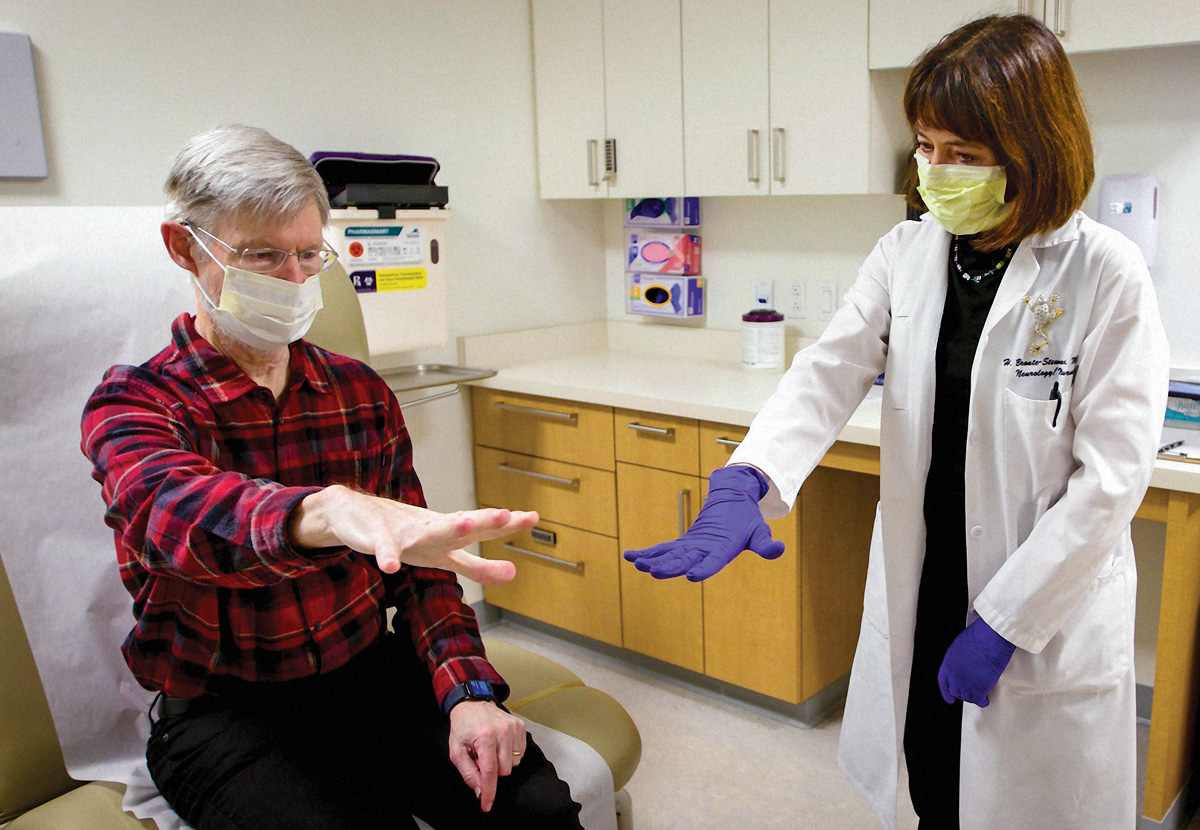 Krehbiel extends his arm during a physical exam with Bronte-Stewart.