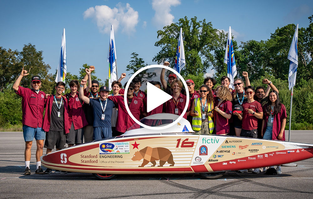 The solar car crew standing behind the solar car.