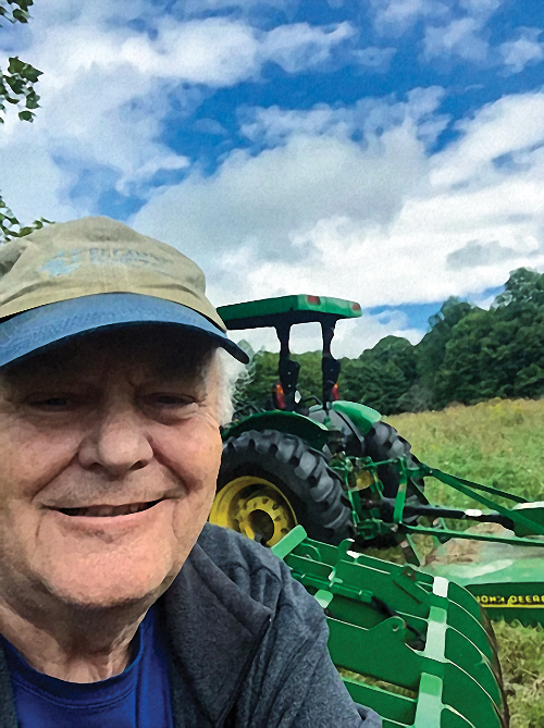 Bruce Beck in front of farm equipment