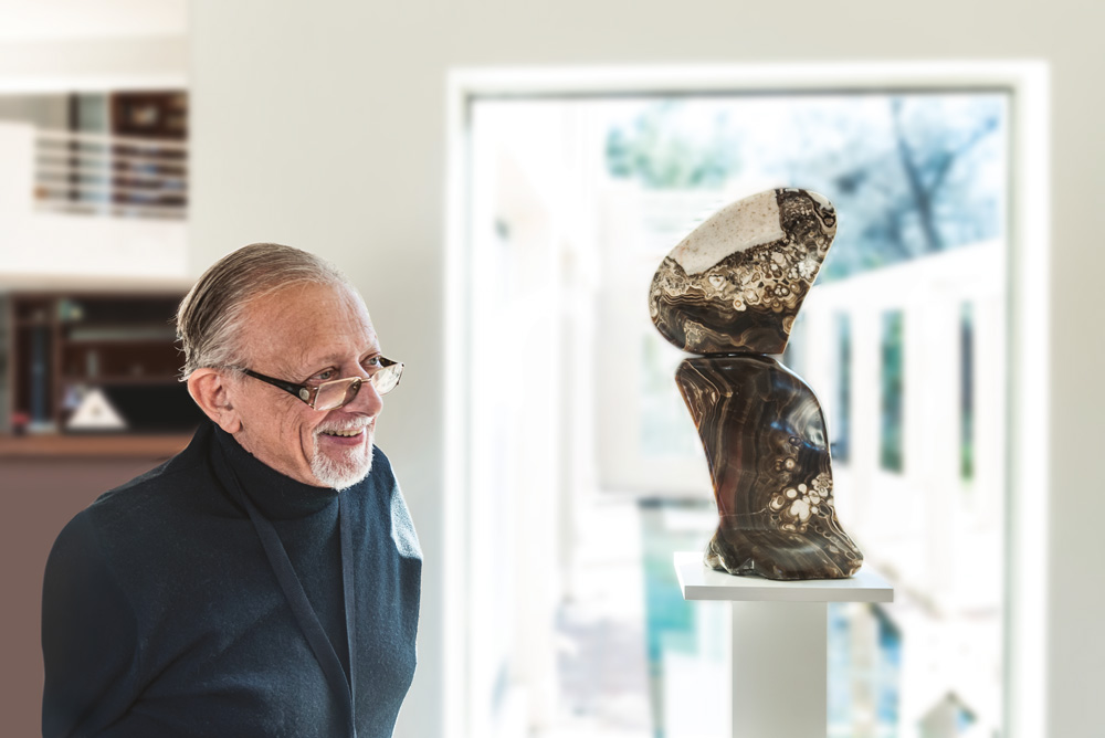Ralph Greco looking at a sculpture