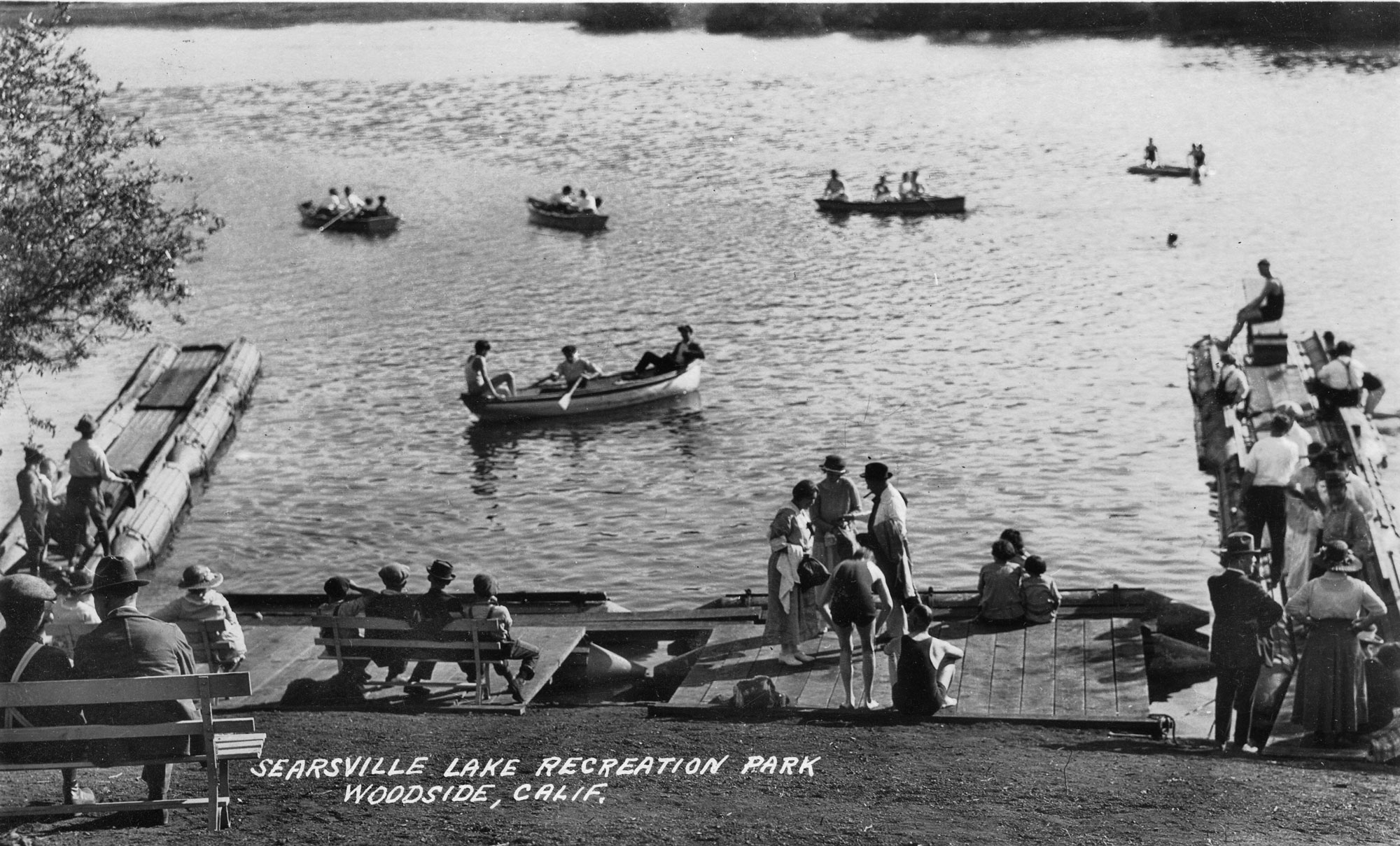 Black and white image of boaters and others at Searsville Lake
