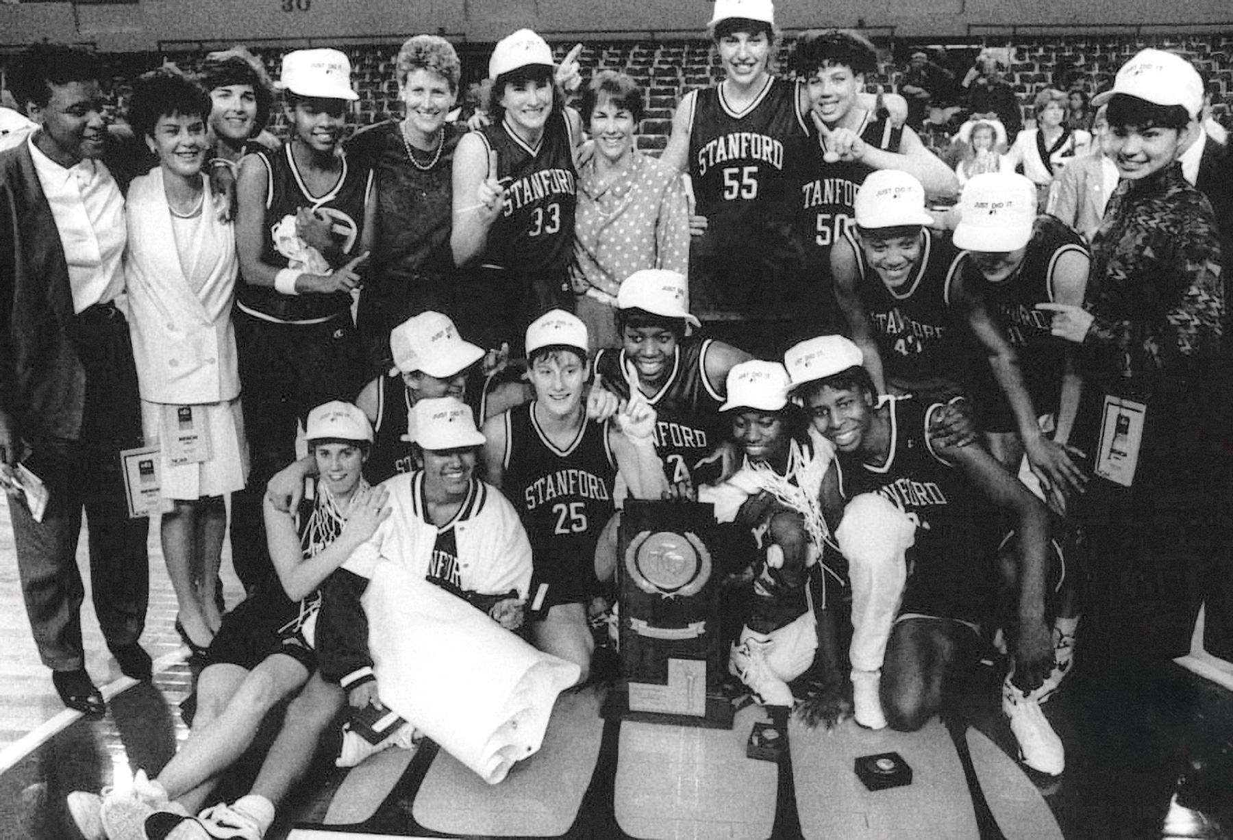 The team poses on the court with their NCAA trophy.
