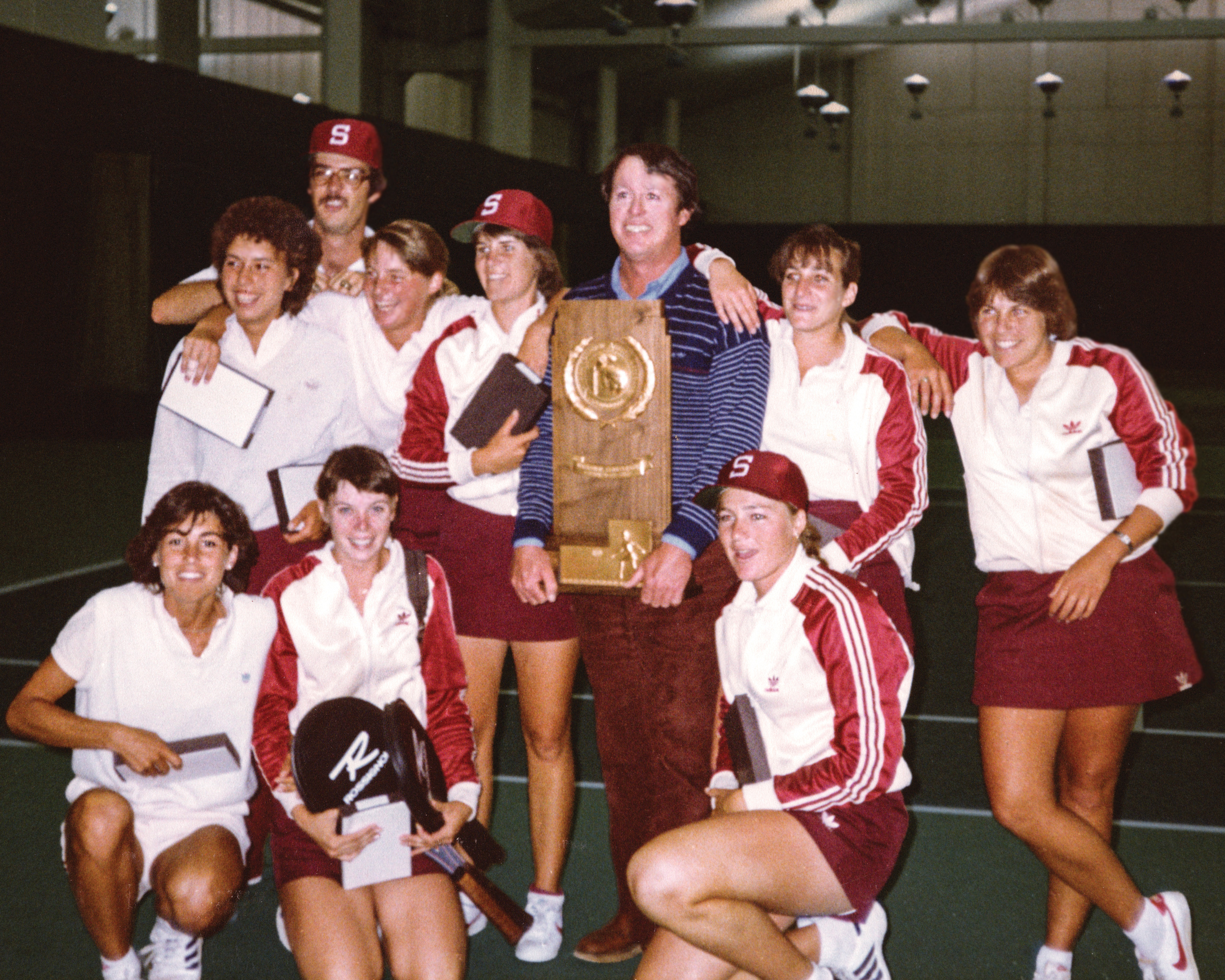 The women's tennis team and coach Brennan with their NCAA trophy.