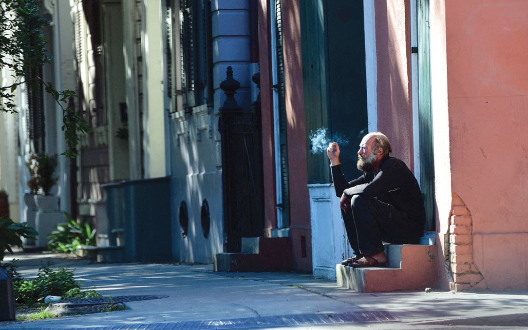 Kevin Bennett sitting on a stoop smoking
