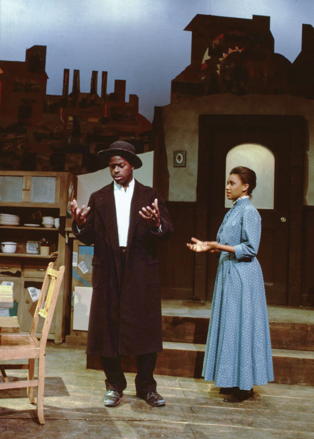 Brown and Bathé on stage in early 20th-century dress, in a household kitchen scene and backdrop.